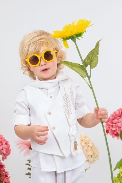 bbbbbbbbbbΒαπτιστικά ρούχα αγόρι Bambolino σετ Nikolas σε λευκό χρώμα με ασύμμετρο γιλέκο, λευκό παντελόνι, λευκό φουλάρι με κέντημα στάχυ και κίτρινα γυαλιά ηλίου.