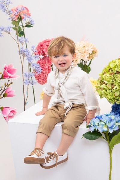 bbbbbbbbbbΒαπτιστικά ρούχα αγόρι Bambolino σετ Jordan με λευκό λινό γιλέκο, λευκό πουκάμισο, camel παντελόνι με λευκό σχοινί στη μέση, λευκό καπέλο και φουλάρι με μπεζ σχέδια.